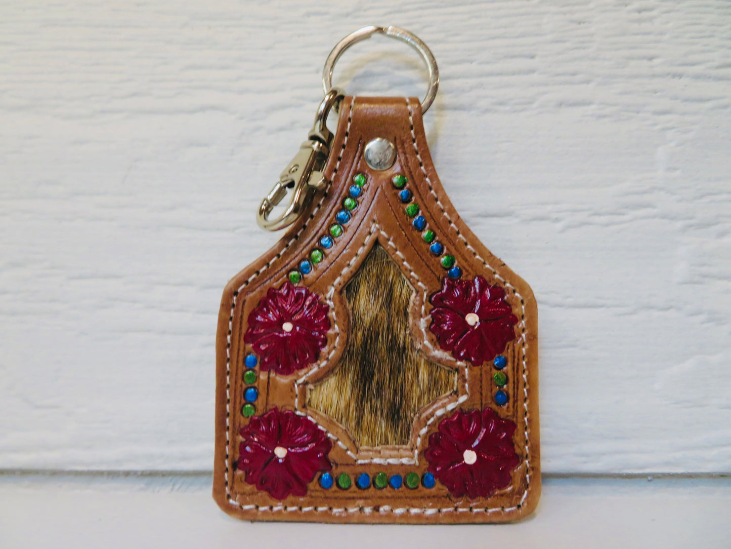 Tooled leather ear tag with cowhide