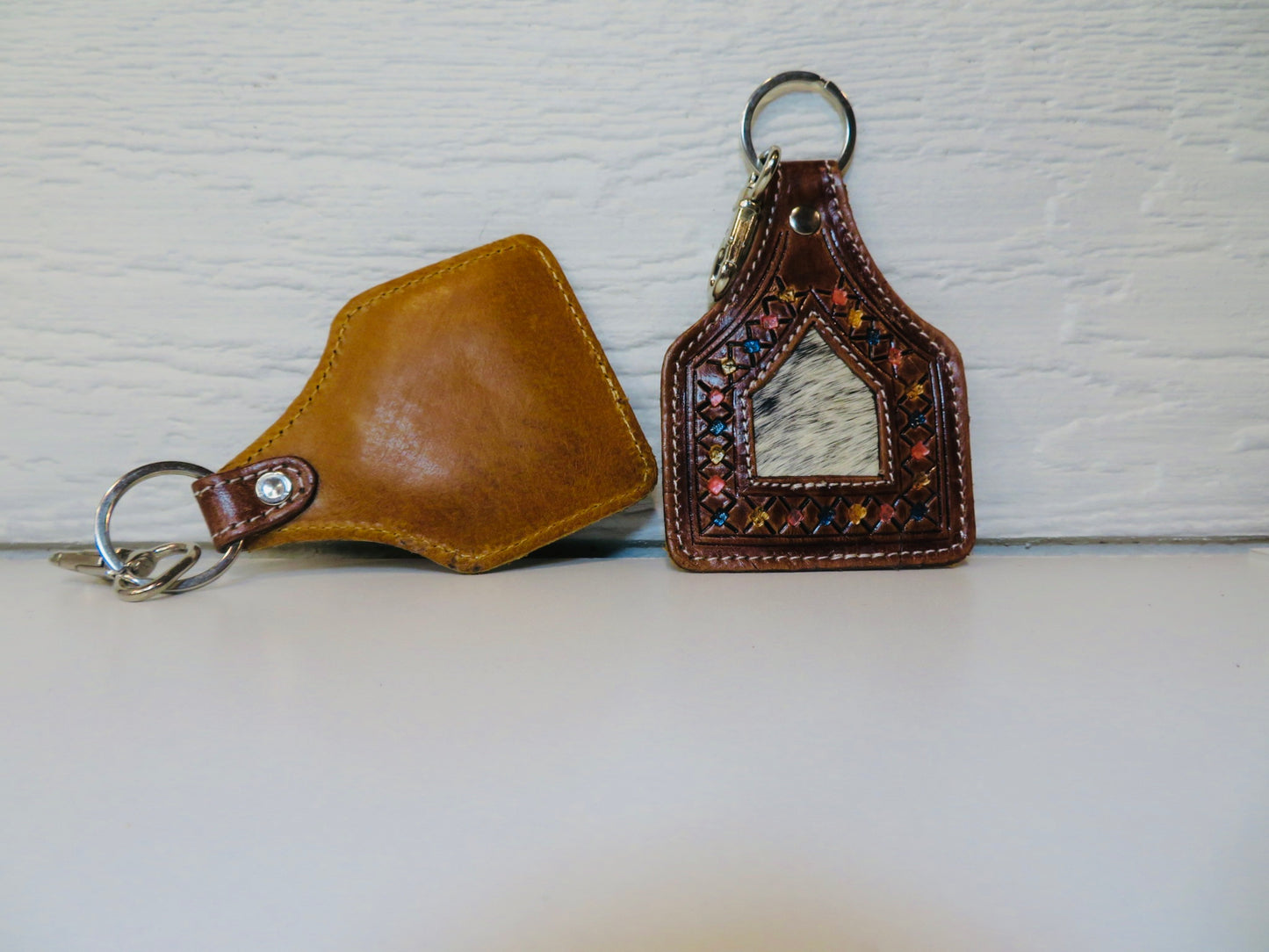 Tooled leather ear tag with cowhide